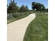 Paved walking path winding through lush green lawns and trees, perfect for leisurely strolls and outdoor enjoyment at 4927 Tarcoola Ln, Highlands Ranch, CO 80130