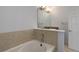 Bathroom with a soaking tub, decorative mirror, neutral finishes and tile at 6821 W Yale Ave, Lakewood, CO 80227