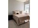 Neutral bedroom featuring a bed with patterned blanket, side table, and window at 6821 W Yale Ave, Lakewood, CO 80227