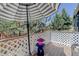 Outdoor patio featuring an umbrella, and table with flowers. Landscaping surrounds the space at 6821 W Yale Ave, Lakewood, CO 80227