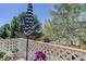 Outdoor patio with white lattice featuring an umbrella, trees and table with flowers at 6821 W Yale Ave, Lakewood, CO 80227