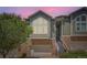 This is a street view of the multi-story home with stone trim, garage, and small yard at 6821 W Yale Ave, Lakewood, CO 80227