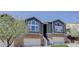 Inviting townhouse featuring an attached garage, stone accents, and a charming landscaped entrance at 6821 W Yale Ave, Lakewood, CO 80227