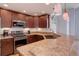 Well-lit kitchen features rich wood cabinetry, granite countertops, and stainless steel appliances at 6821 W Yale Ave, Lakewood, CO 80227