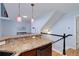 Kitchen bar with granite countertops and stylish pendant lighting leads to the upstairs staircase at 6821 W Yale Ave, Lakewood, CO 80227