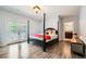 Bright main bedroom with hardwood floors, black four-poster bed, a full bathroom and doors that lead to the outdoors at 6821 W Yale Ave, Lakewood, CO 80227