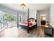 Bedroom with hardwood floors, a four-poster bed and a door opening onto the balcony provides a bright and airy feel at 6821 W Yale Ave, Lakewood, CO 80227