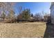 A large, unfenced backyard featuring sparse grass and surrounding trees at 10903 Parker Vista Way, Parker, CO 80138