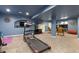 Finished basement includes a treadmill, television, and seating area, all in a well-lit space at 10903 Parker Vista Way, Parker, CO 80138