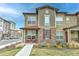 Charming townhome featuring stone accents, a well-manicured lawn, and a cozy front porch at 8376 Lorenzo Ln # A, Highlands Ranch, CO 80129