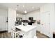 Bright kitchen boasts white cabinets, a center island with seating, and stainless steel appliances at 8376 Lorenzo Ln # A, Highlands Ranch, CO 80129