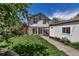 Beautiful backyard featuring lush green grass, mature trees, and a charming home exterior with a deck at 1250 S Vine St, Denver, CO 80210