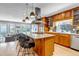 Gourmet kitchen featuring custom wood cabinetry, stainless steel appliances, and a center island with seating at 1250 S Vine St, Denver, CO 80210