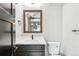 Stylish bathroom featuring white countertops, a dark vanity, modern fixtures, and a dark framed mirror at 3224 W Dakota Ave, Denver, CO 80219