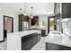 Modern kitchen with stainless steel appliances, a center island with a sink, and marble floors at 3224 W Dakota Ave, Denver, CO 80219