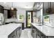 Contemporary kitchen featuring a large island with a sink, a black faucet and marble countertops at 3224 W Dakota Ave, Denver, CO 80219