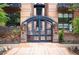 Elegant gated entrance with stone pillars and manicured landscaping at Metro Lofts at 930 Acoma St # 106, Denver, CO 80204