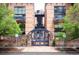 Charming brick building featuring a secure gate and well-maintained landscaping at 930 Acoma St # 106, Denver, CO 80204