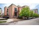 A charming brick condo building with lush trees and street parking at 930 Acoma St # 106, Denver, CO 80204