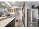 Kitchen area with stainless steel refrigerator, countertops, and access to the hallway at 930 Acoma St # 106, Denver, CO 80204