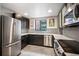 Contemporary kitchen featuring stainless steel appliances, dark cabinetry, and stylish backsplash at 930 Acoma St # 106, Denver, CO 80204