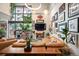 Open-concept living room with plants, modern decor, large windows and comfortable leather furniture at 930 Acoma St # 106, Denver, CO 80204