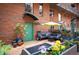 Serene outdoor patio featuring a seating area, vibrant potted plants, and a green door at 930 Acoma St # 106, Denver, CO 80204
