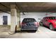 Well-lit parking garage featuring parking spaces with black Mercedes sedan and red SUV at 930 Acoma St # 106, Denver, CO 80204