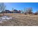 Sprawling backyard with a blend of dry grass and some snow, offering a peaceful retreat at 5107 Appleton Way, Castle Rock, CO 80104