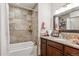 Well-lit bathroom featuring a tub-shower combination, tiled surround, and dark wood vanity at 5107 Appleton Way, Castle Rock, CO 80104