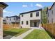 Charming backyard features a well-maintained lawn and modern two-story home with privacy fence at 2515 N Gaylord St, Denver, CO 80205