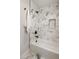 Elegant bathroom showcasing a white tiled tub and shower with contrasting black fixtures at 2515 N Gaylord St, Denver, CO 80205