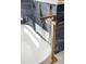 Close up on modern stand alone bathtub with gold faucet fixture at 2515 N Gaylord St, Denver, CO 80205