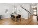 Bright dining room features modern lighting fixture, wood floors, and black chairs around the wooden table at 2515 N Gaylord St, Denver, CO 80205