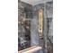 Close up on gold shower fixture and gray marble tile in modern bathroom at 2515 N Gaylord St, Denver, CO 80205