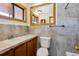 Neutral bathroom features a wood framed mirror, updated vanity and fixtures, and a toilet at 8182 3Rd Ave, Arvada, CO 80007