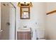 Bathroom with a vanity, open-shelved medicine cabinet, and tiled walk-in shower at 8182 3Rd Ave, Arvada, CO 80007