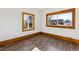 Bedroom featuring a wood laminate floor, two windows and white walls at 8182 3Rd Ave, Arvada, CO 80007