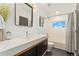 Bathroom featuring a large mirror, a vanity with storage, and a shower over tub at 3657 Pecos St, Denver, CO 80211