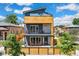 Modern three-story home featuring wood accents and a welcoming front porch at 3657 Pecos St, Denver, CO 80211