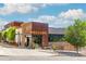 Charming street view of Postino restaurant under sunny blue skies with lush green trees at 3657 Pecos St, Denver, CO 80211