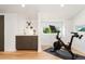Home gym featuring Peloton bike, wood floors, and a modern sink area at 3657 Pecos St, Denver, CO 80211