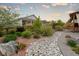 Lush backyard featuring a decorative stone pathway, vibrant flowers, and mature trees, creating a serene outdoor oasis at 565 Pikes View Dr, Erie, CO 80516