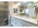 Modern bathroom featuring double sinks, granite countertops, updated fixtures, and tiled shower with glass doors at 565 Pikes View Dr, Erie, CO 80516