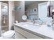 Bathroom with sleek vanity, marble countertop, modern fixtures, large mirror, and glass-enclosed shower for a spa-like experience at 565 Pikes View Dr, Erie, CO 80516