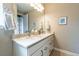 Inviting bathroom with double vanity, granite countertops, and decorative art at 565 Pikes View Dr, Erie, CO 80516