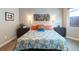 Bright bedroom with floral patterned bedding, side tables, and decorative wall art creating a cozy and stylish space at 565 Pikes View Dr, Erie, CO 80516