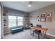 Bright bedroom with large window, modern ceiling fan, and a curated collection of framed art pieces at 565 Pikes View Dr, Erie, CO 80516