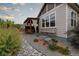 Exterior view of the house showing a stone garden, an attached pergola, and large windows bringing in natural light at 565 Pikes View Dr, Erie, CO 80516