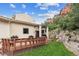 Lovely back deck with wooden railings and a view of a grassy lawn and natural rocky landscape at 5085 Red Rock Dr, Larkspur, CO 80118